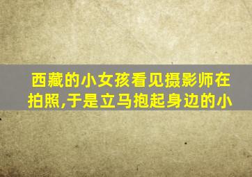 西藏的小女孩看见摄影师在拍照,于是立马抱起身边的小